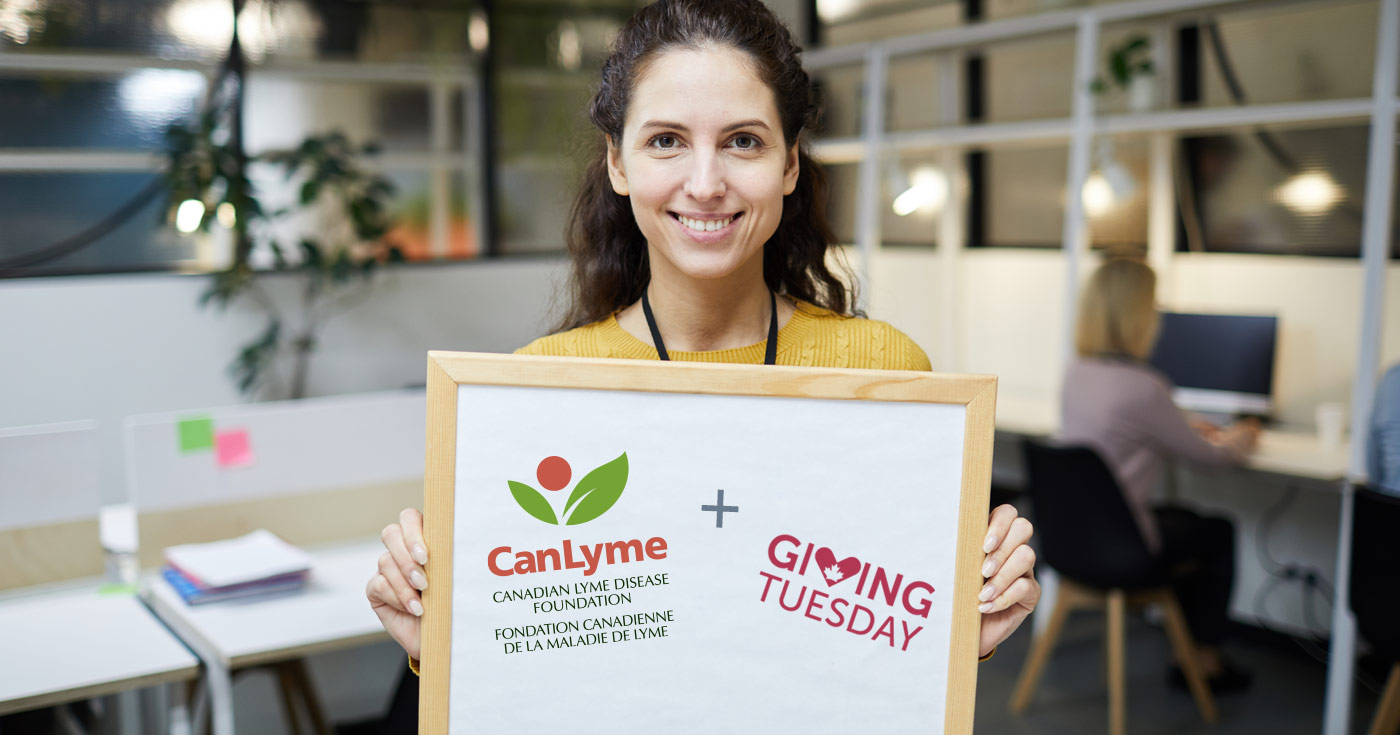 Une femme tient un tableau blanc qui dit CanLyme plus Giving Tuesday.