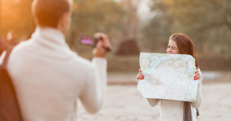 Un couple célèbre leurs plans de voyage en tenant une carte pour une photo.