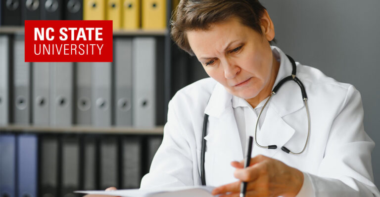 Nc State University médecin et chercheur est assis à lire à son bureau.